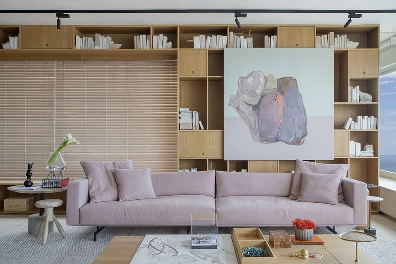 Sala de estar; sofá rosa claro; estante com nichos; quadro
