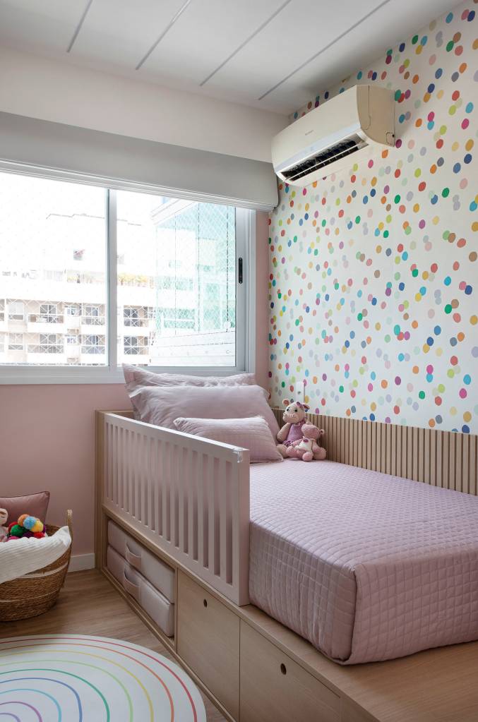 Quarto infantil com cama em plataforma de madeira e papel de parede.