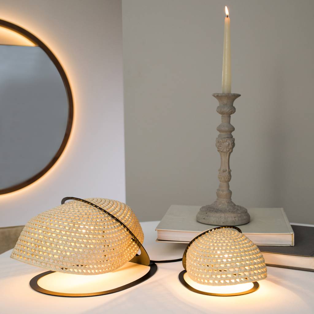 Tetu Design_luminária Tatupeba-G-e-P Luminária Tatupeba: a peça utiliza estrutura metálica preta com cúpula desenvolvida pelos artesãos de Aracati (CE). O formato curvo e ovalado lembra o tatu da caatinga e a trama da palha de Carnaúba trançada tem inspiração na textura do casco do animal.
