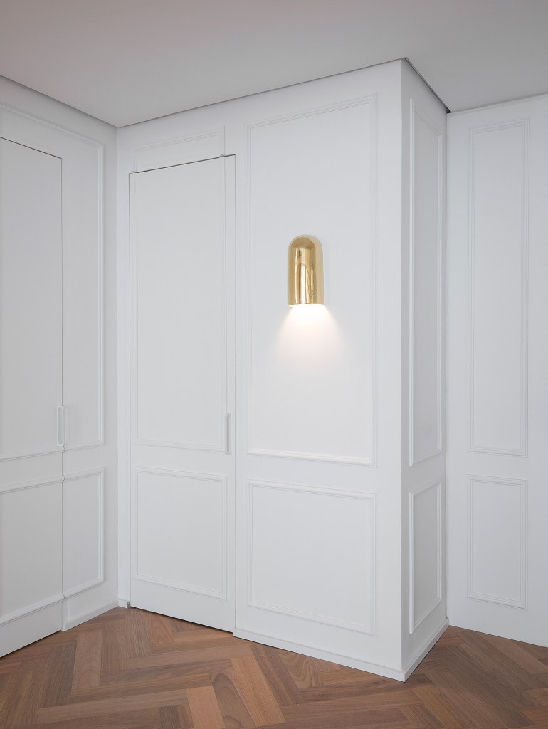 Apartamento ar parisiense movimento minimalista estilo nova-iorquino. Gabriela Casagrande sala estar boiserie luminaria porta