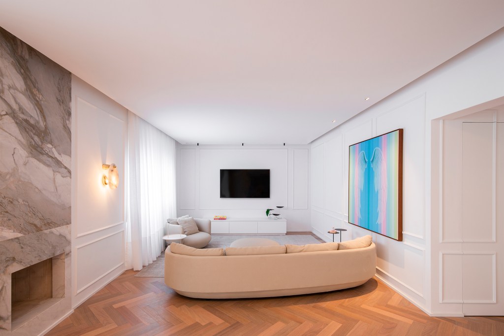 Apartamento ar parisiense movimento minimalista estilo nova-iorquino. Gabriela Casagrande sala estar cortina poltrona boiserie sofa tv lareira