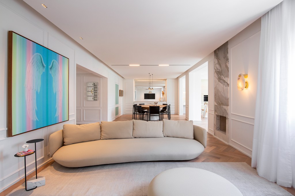 Apartamento ar parisiense movimento minimalista estilo nova-iorquino. Gabriela Casagrande sala de jantar mesa oval cadeiras preta boiserie sofa quadro lareira