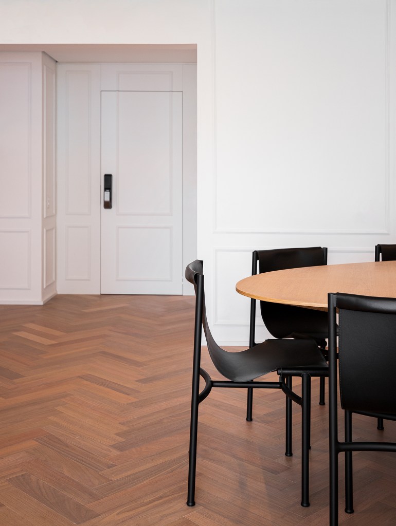 Apartamento ar parisiense movimento minimalista estilo nova-iorquino. Gabriela Casagrande sala de jantar mesa oval cadeiras preta boiserie