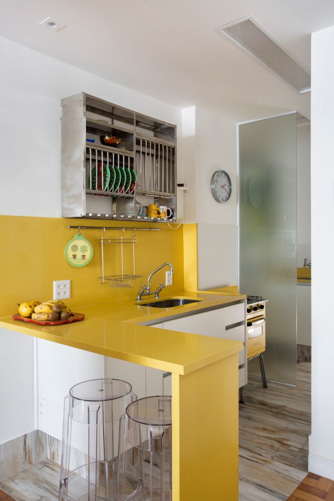Cozinha pequena com bancada amarela.