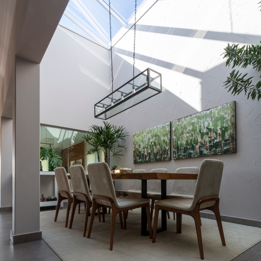 Casa 250 m2 iluminação zenital sala de jantar Inovando Arquitetura sala jantar mesa cadeira lustre corredor