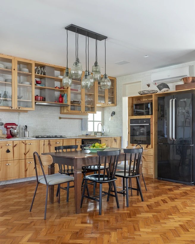 Sala integrada com cozinha com composição de cadeiras; piso de taco