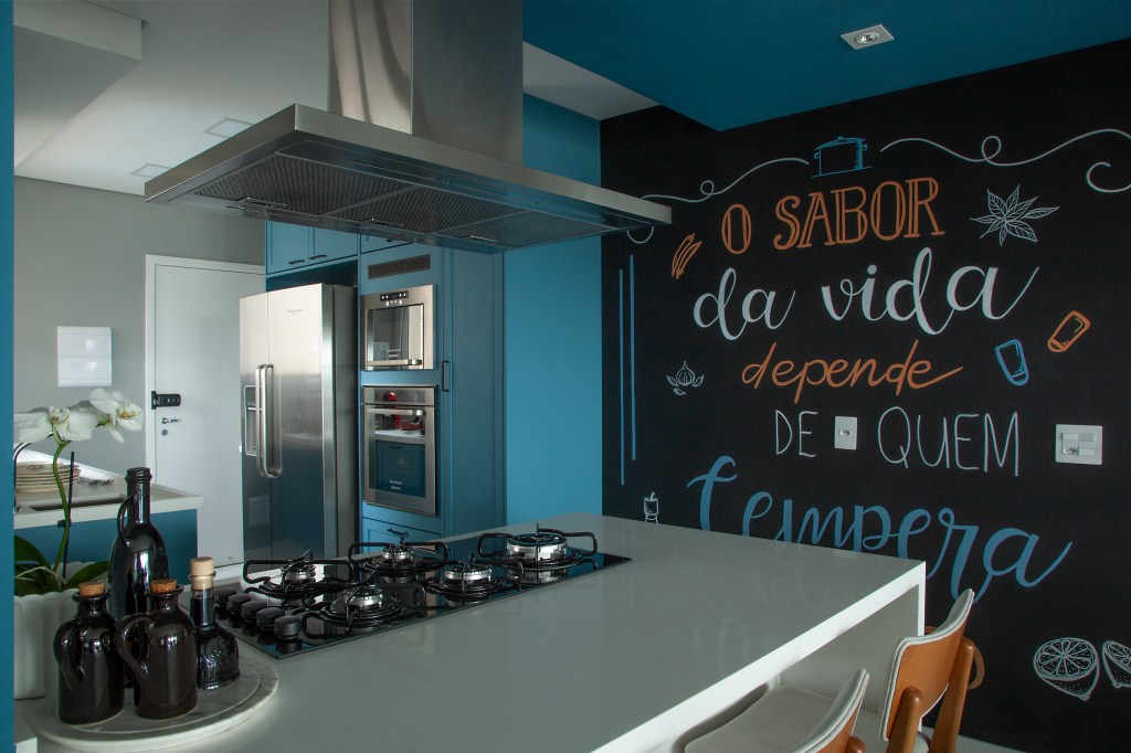 Cozinha com parede azul e bancada branca