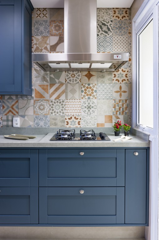 Cozinha com armários vintage azuis e backsplash de azulejos coloridos