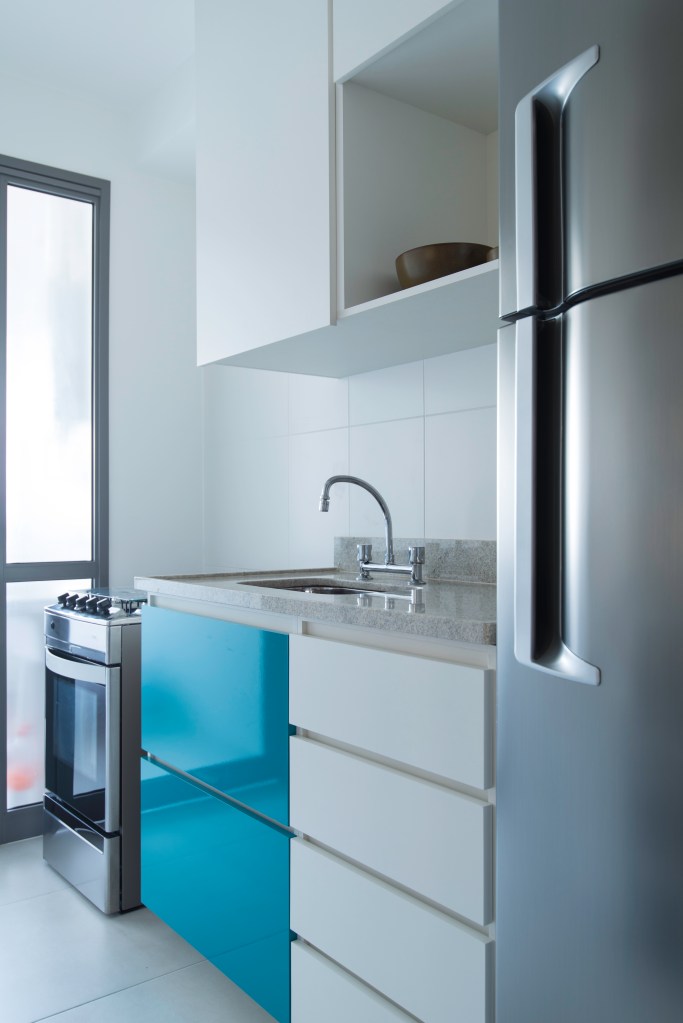 Cozinha pequena com armários azuis e brancos; cozinha estreita