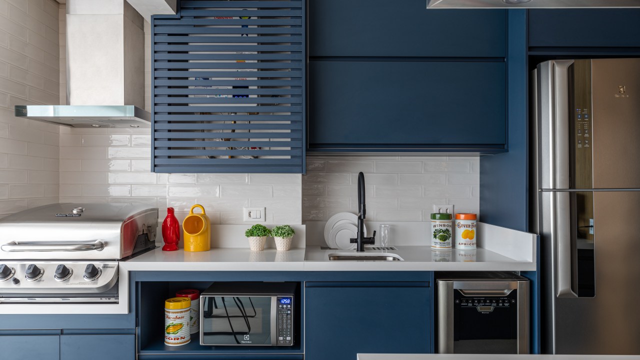 Cozinha americana; cozinha integrada com piso hexagonal, bancada branca e marcenaria azul.