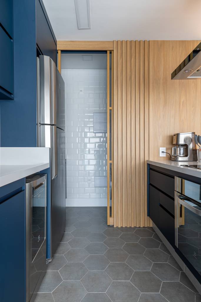 cozinha-protagonista-ape-66m-atmosfera-industrial-cadda-arquitetura-11 Cozinha americana; cozinha integrada com piso hexagonal, bancada branca e marcenaria azul.