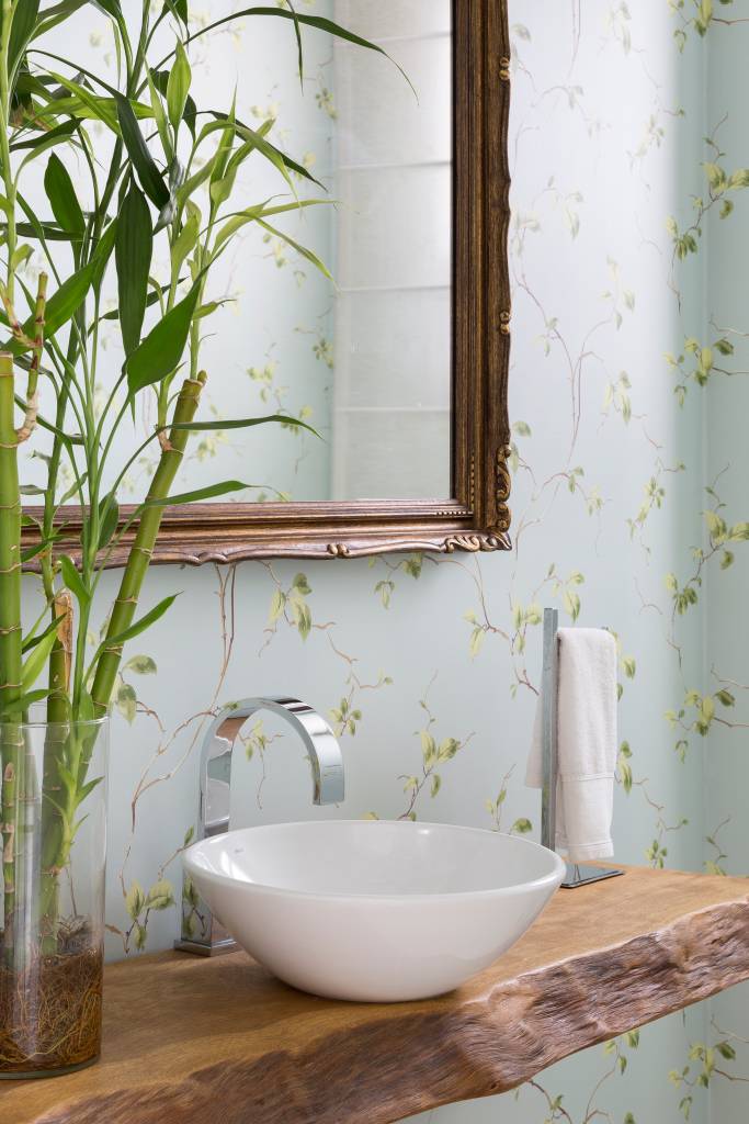 Lavabo com bancada de madeira e papel de parede floral