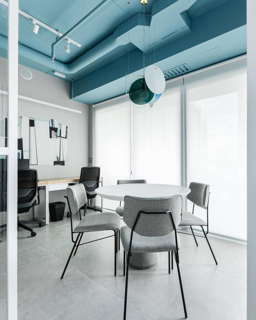 Área comercial com teto colorido azul; piso de porcelanato e decoração cinza