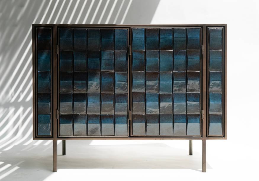 O Aparador Marinho é feito de aço patinado e cerâmica com armário criado por Ricardo van Steen e desenvolvido em parceria com o designer argentino Leo Ceolin, mestre da metalurgia na Oficina Lab em São Paulo. As cerâmicas foram desenhadas por van Steen e queimadas em argila preta, pelo Mestre Waguinho da Oficina Cerâmica Pé da Serra e por seu filho Tiago. Cada peça foi feita à mão em argila preta no Sertão do Piavú, em São Sebastião (SP), em forno de alta temperatura com queima a gás. O Aparador Marinho é feito de aço patinado e cerâmica com armário criado por Ricardo van Steen e desenvolvido em parceria com o designer argentino Leo Ceolin, mestre da metalurgia na Oficina Lab em São Paulo. As cerâmicas foram desenhadas por van Steen e queimadas em argila preta, pelo Mestre Waguinho da Oficina Cerâmica Pé da Serra e por seu filho Tiago. Cada peça foi feita à mão em argila preta no Sertão do Piavú, em São Sebastião (SP), em forno de alta temperatura com queima a gás.