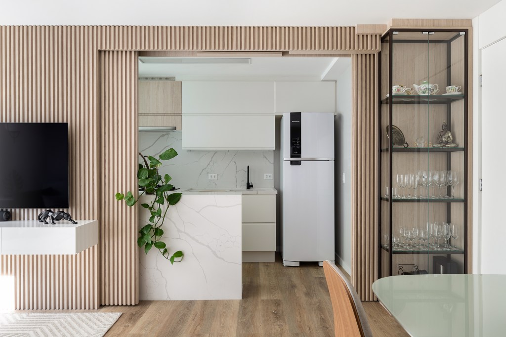 Apartamento 56 m2 painel de correr ripado décor minimalista Tulli Estudio decoracao cozinha sala tv madeira mesa bancada