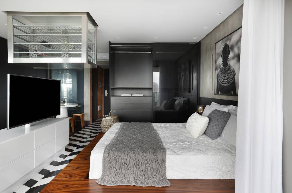 Apê de 46 m² possui adega suspensa e cozinha preta escondida