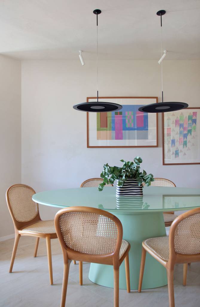ape-85m-cozinha-integrada-decor-urbano-studio-pipa-arquitetura-10-jantar Sala de jantar com mesa redonda verde laqueada e cadeiras de madeira.