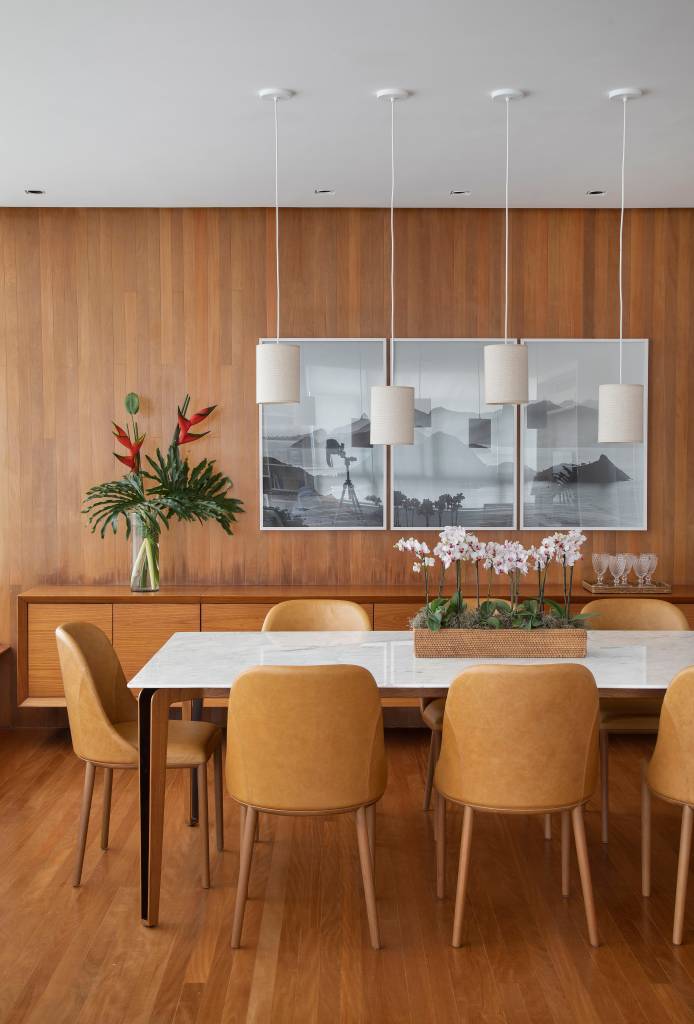 Sala de jantar com buffet, mesa de tampo branco e cadeiras terracota.