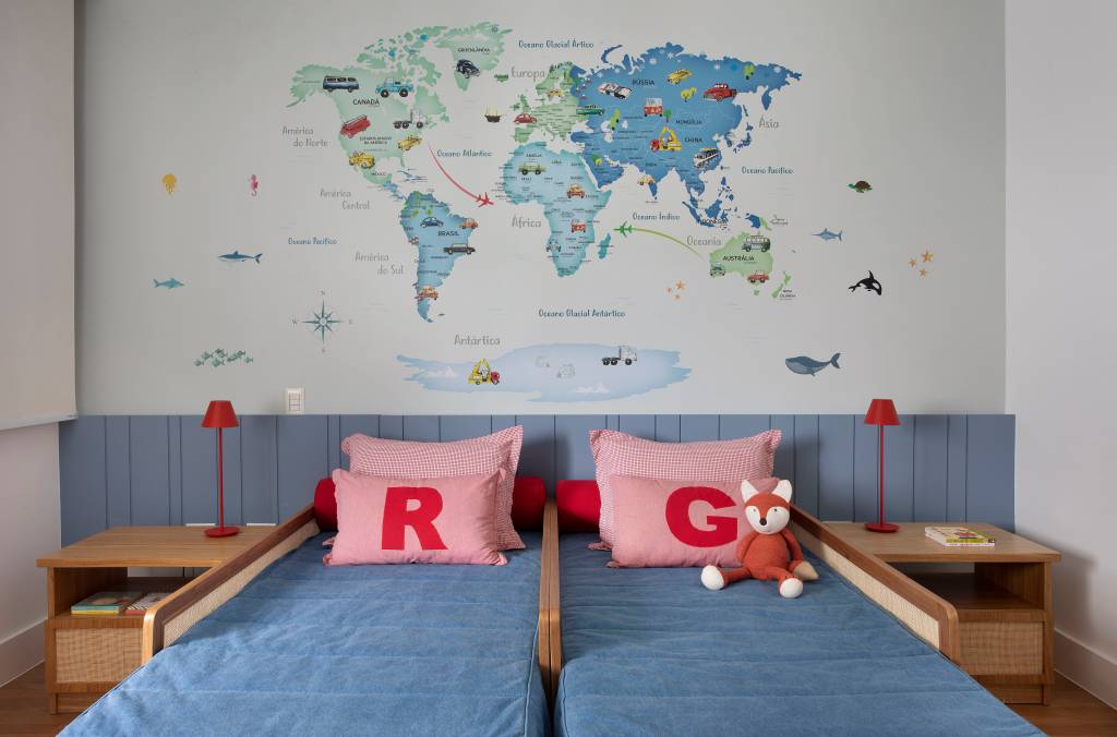 Quarto infantil com cabeceira azul, duas bicamas e mural de mapa múndi.