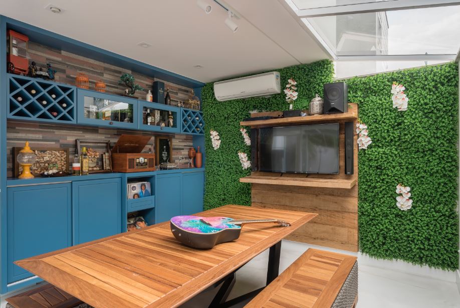 Cozinha com marcenaria azul e parede verde; jardim vertical.