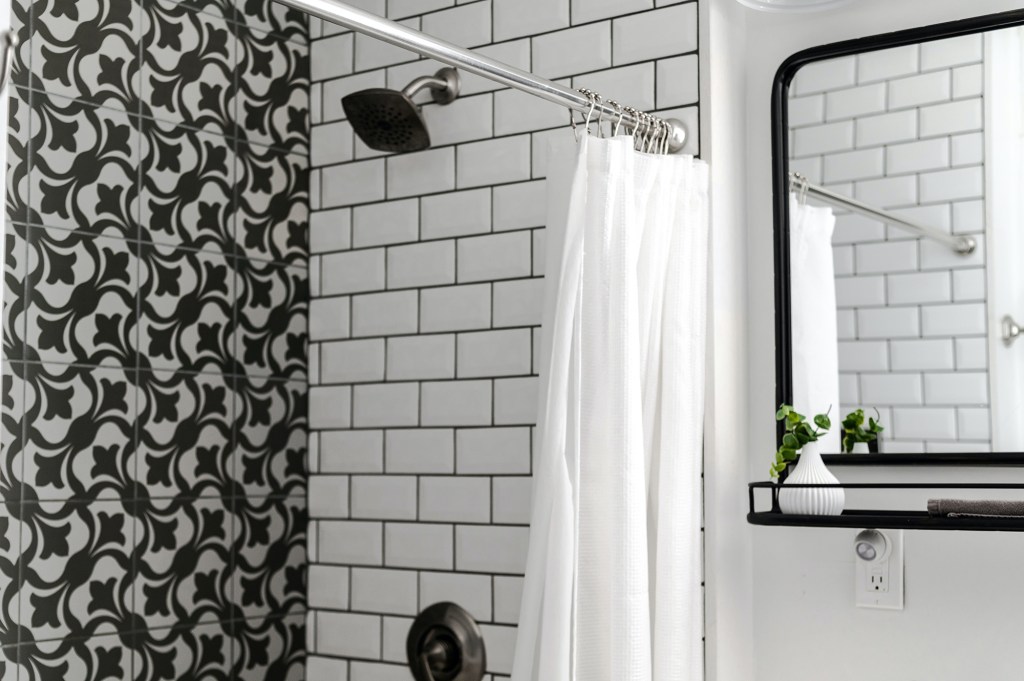 Banheiro americano com parede de subway tiles, cortina e ducha.
