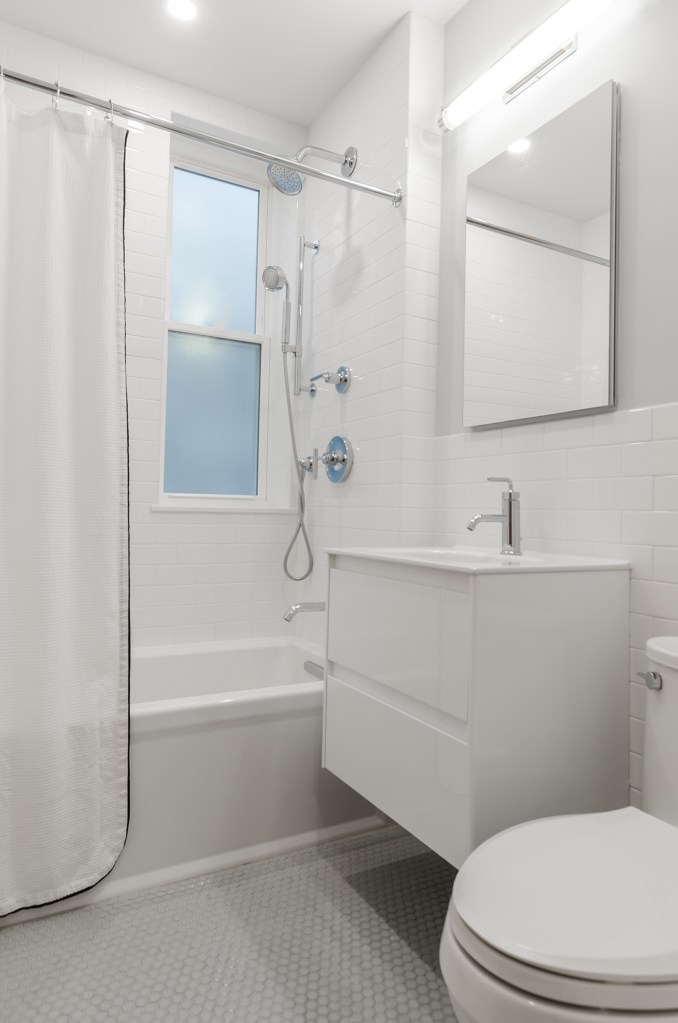 Banheiro americano branco com marcenaria branca e cortina de banho.