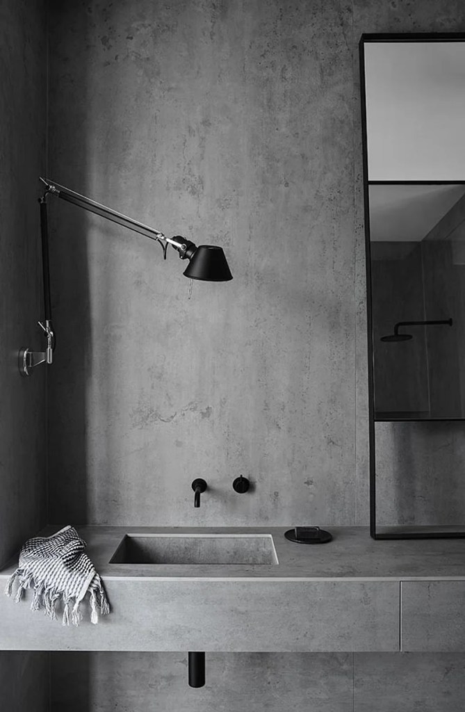 Banheiro minimalista com revestimento em estilo cimento queimado.