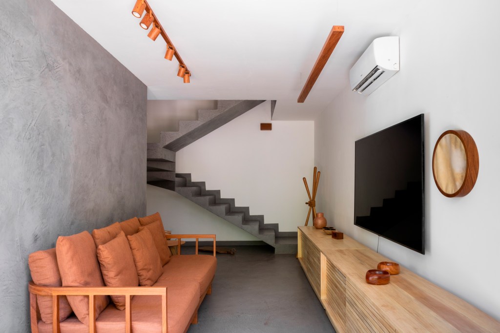 Casa sustentável Bahia conceito rústico elementos regionais Alphaz Concept decoração sala tv sofa cimento queimado madeira escada