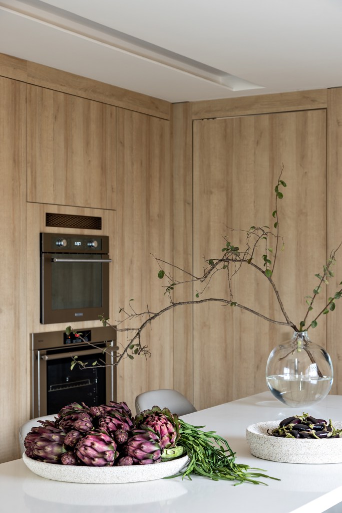 Cozinha layout clean elegante revestimento amadeirado Mota Arquitetura amario torre quente ilha