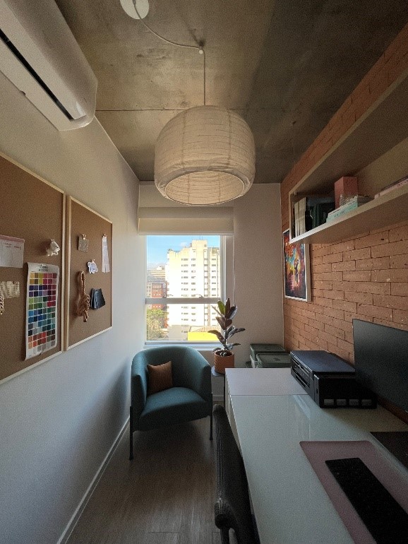 Home office pequeno com parede de tijolinhos.
