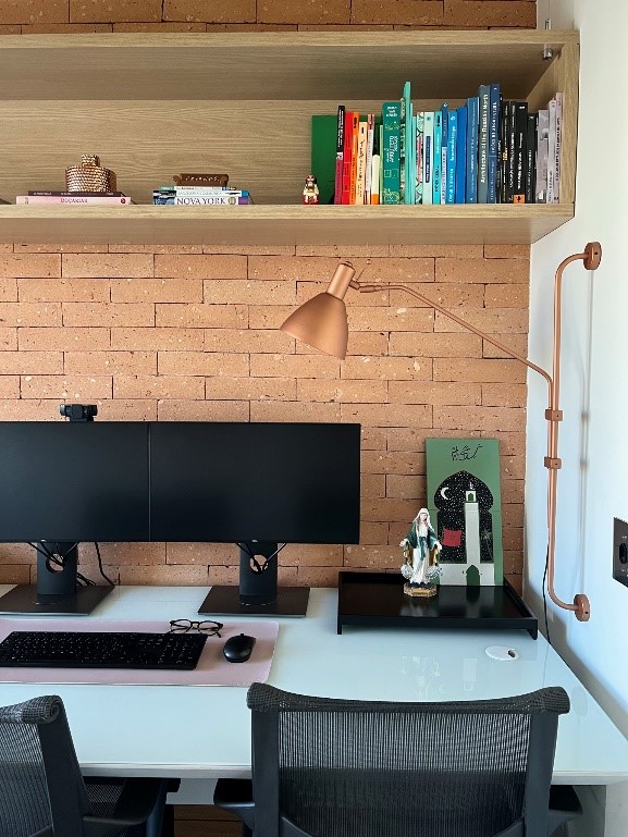 Home office pequeno com parede de tijolinhos.