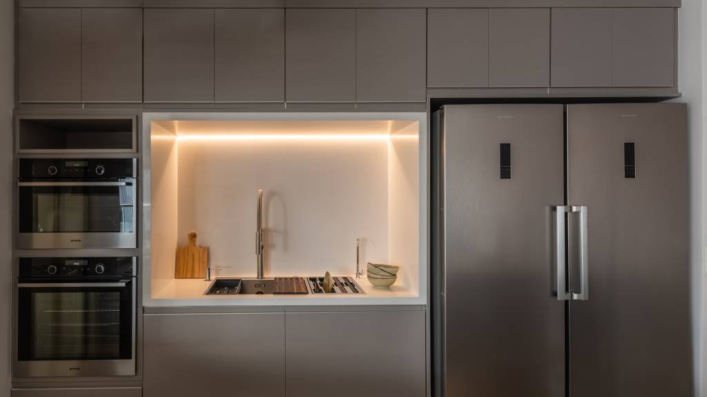 iluminacao-led-elegancia-sobria-ape-95m-bma-studio-02 Cozinha cinza com ilha, bancada branca e marcenaria cinza escura.