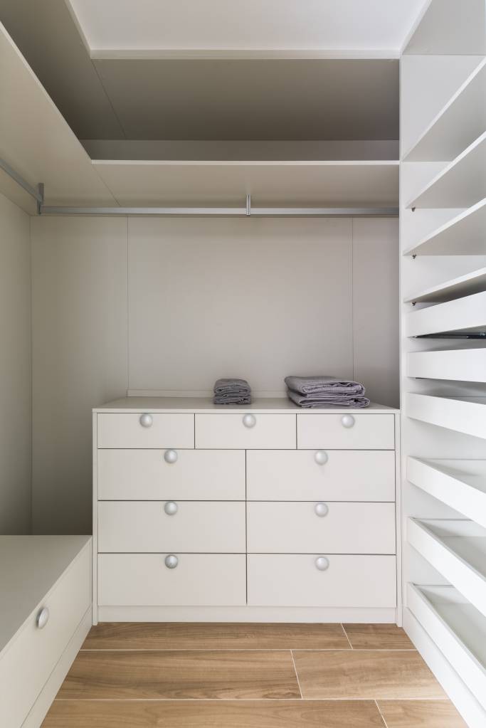 iluminacao-led-elegancia-sobria-ape-95m-bma-studio-21-closet Closet com armários brancos e porta de vidro.