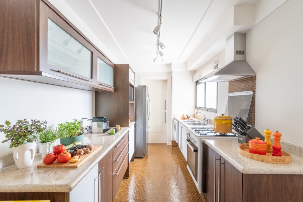 Cozinha com piso laranja e marcenaria planejada.