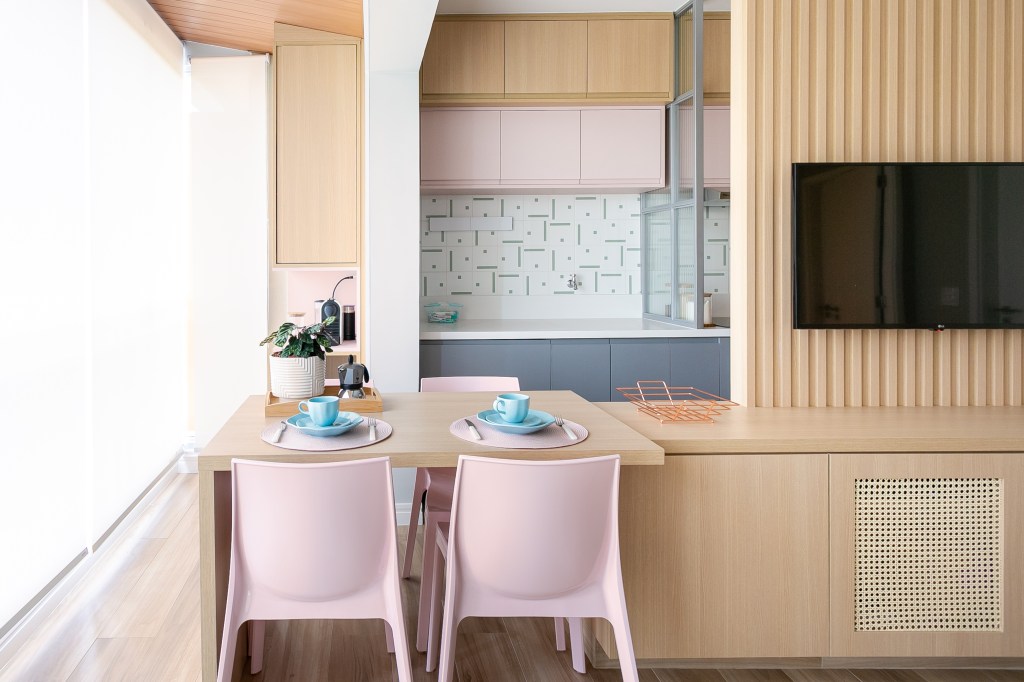 Mesa cozinha estende varanda apê 47 m2 Loft 7 Arquitetura apartamento pequeno decoração sala cozinha painel madeira rosa cinza tv madeira
