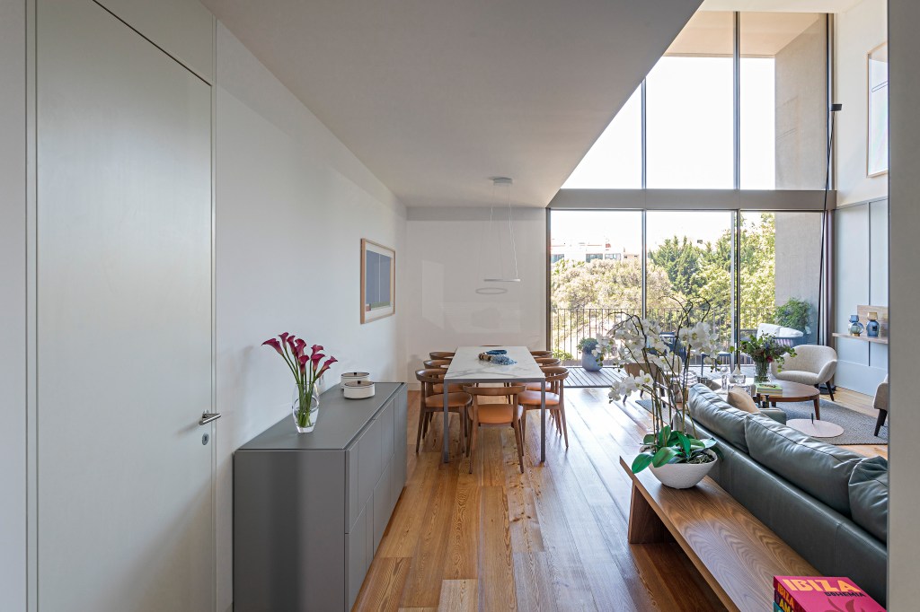 Sala pé-direito duplo integrada varanda apê Portugal Andrea Chicharo decoracao jantar mesa cadeira madeira quadro