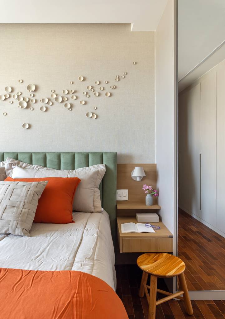 Quarto com cama de casal com cabeceira acolchoada verde.