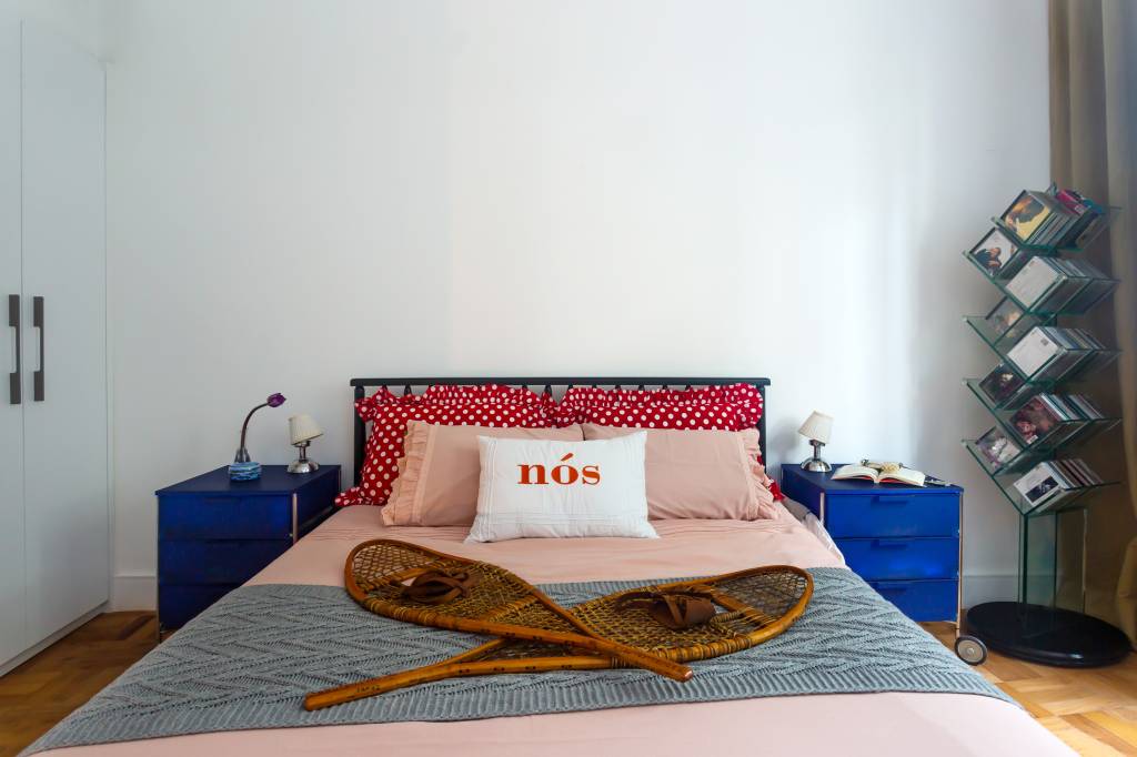 Quarto com cama de casal e almofada estampada.