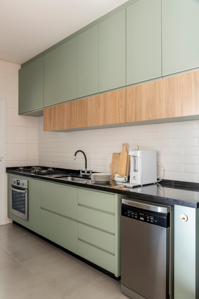 Cozinha com armários verde claros.