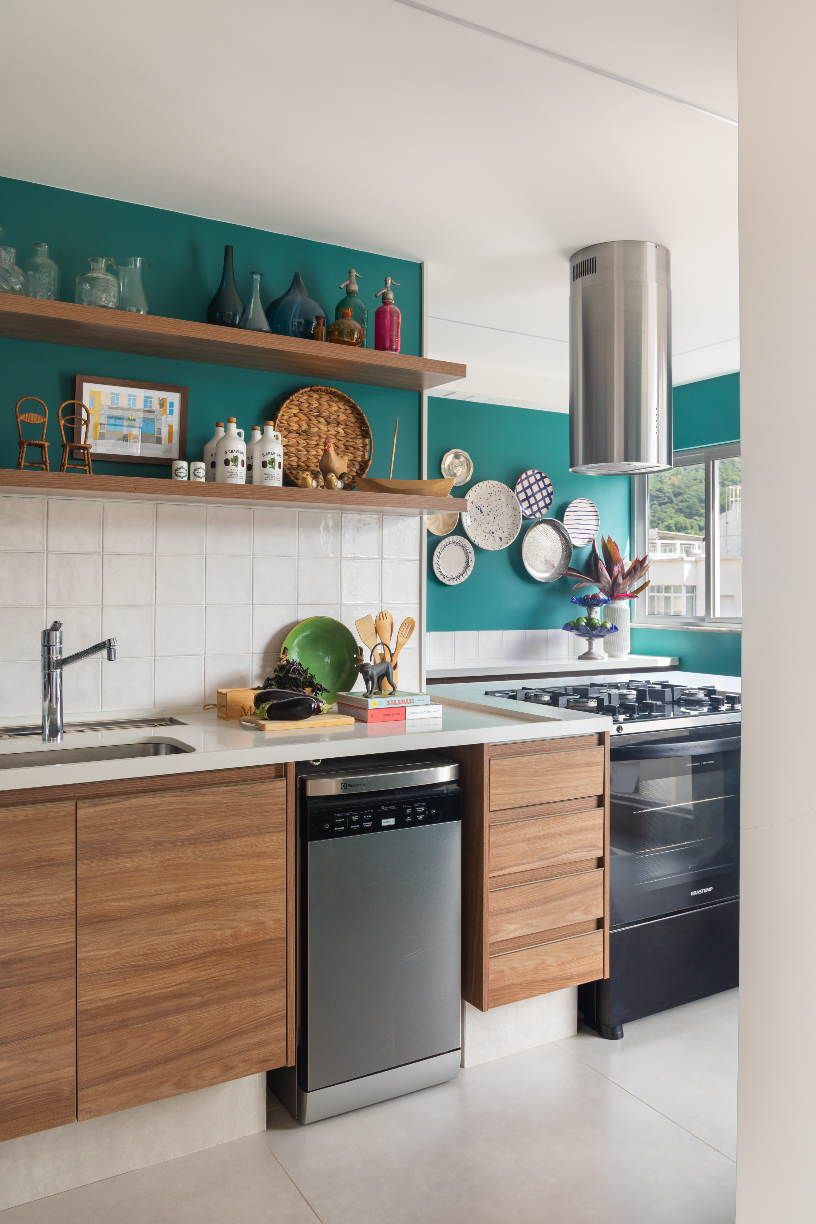Cozinha com parede verde, backsplash de azulejos brancos e coifa.