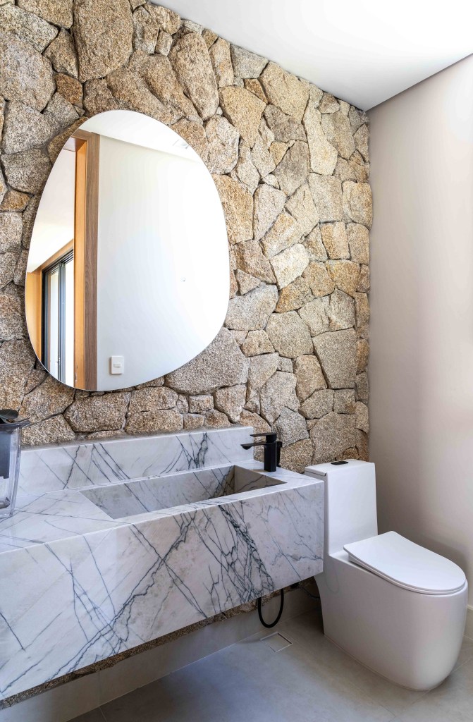 Casa 502 m2 arquitetura clean atemporal Casalli Arquitetura decoração banheiro lavabo pedra espelho organico