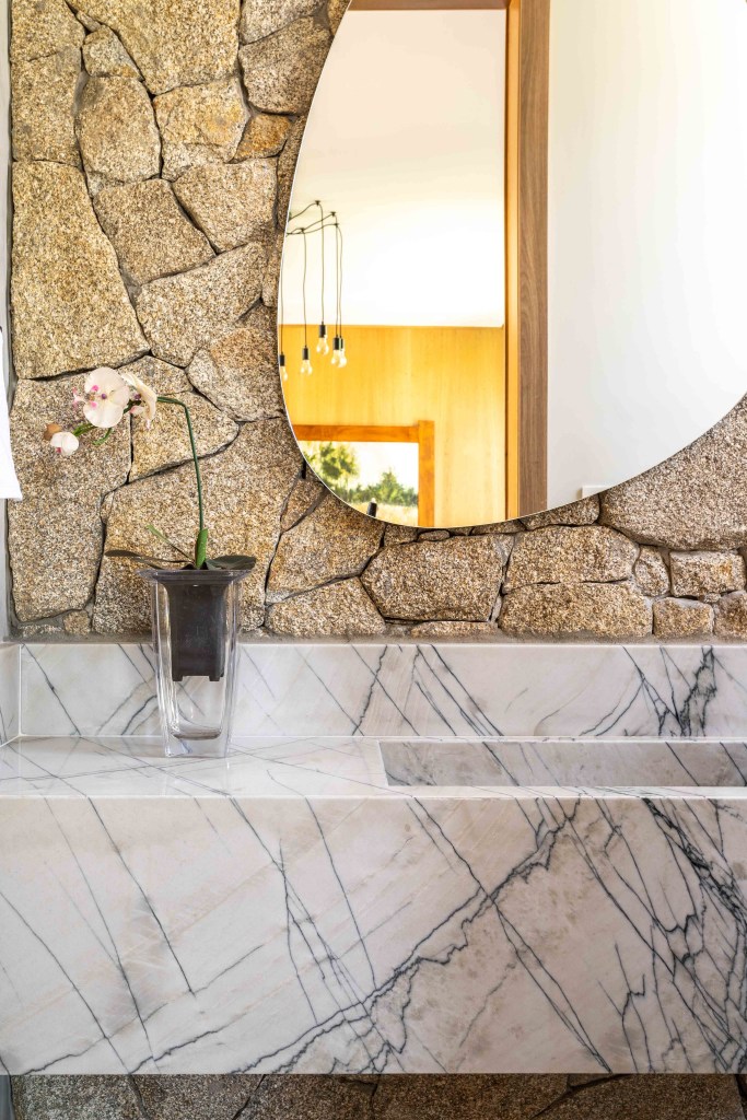 Casa 502 m2 arquitetura clean atemporal Casalli Arquitetura decoração banheiro lavabo pedra espelho organico