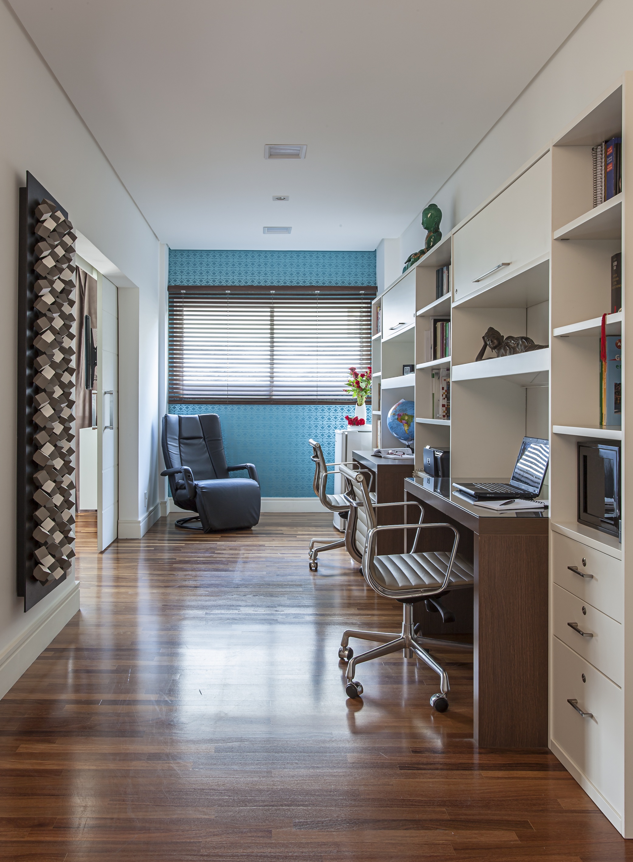 Home office para duas pessoas com piso de madeira, marcenaria planejada e parede azul.