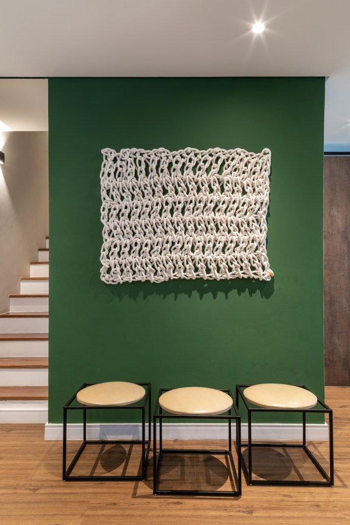 3 jeitos fáceis de usar materiais naturais na decoração; Na foto, hall de entrada com parede verde com bancos e macramê.