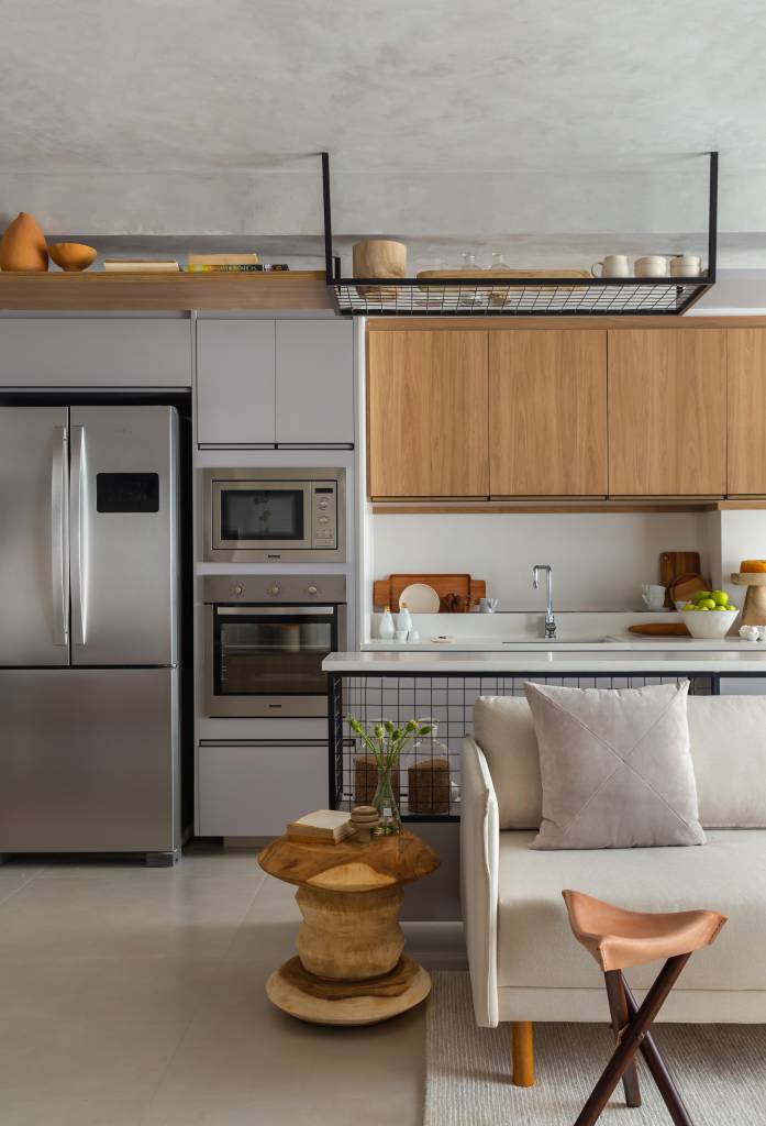 Cozinha americana; Sala integrada com cozinha com piso de porcelanato e sofá branco.