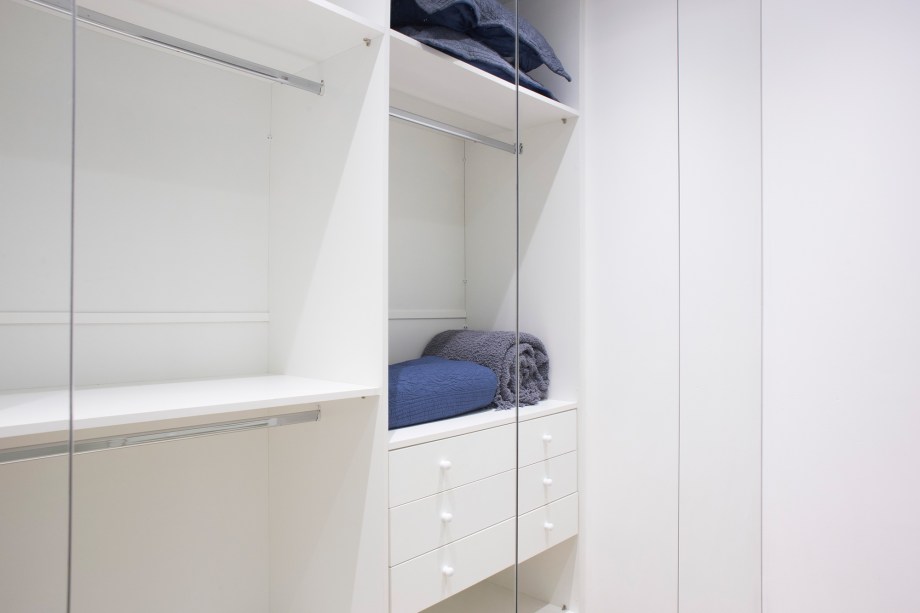 Cinza e azul e lavanderia dentro do armário marcam este apê de 29 m²