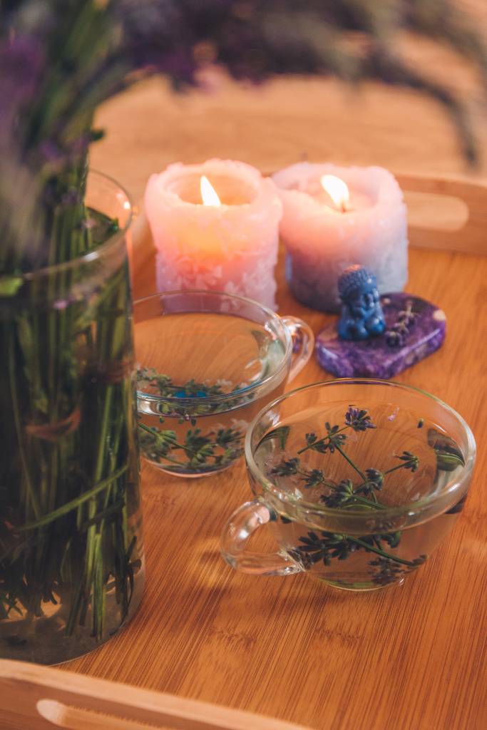 Velas aromáticas em mesa de madeira com óleos essenciais.