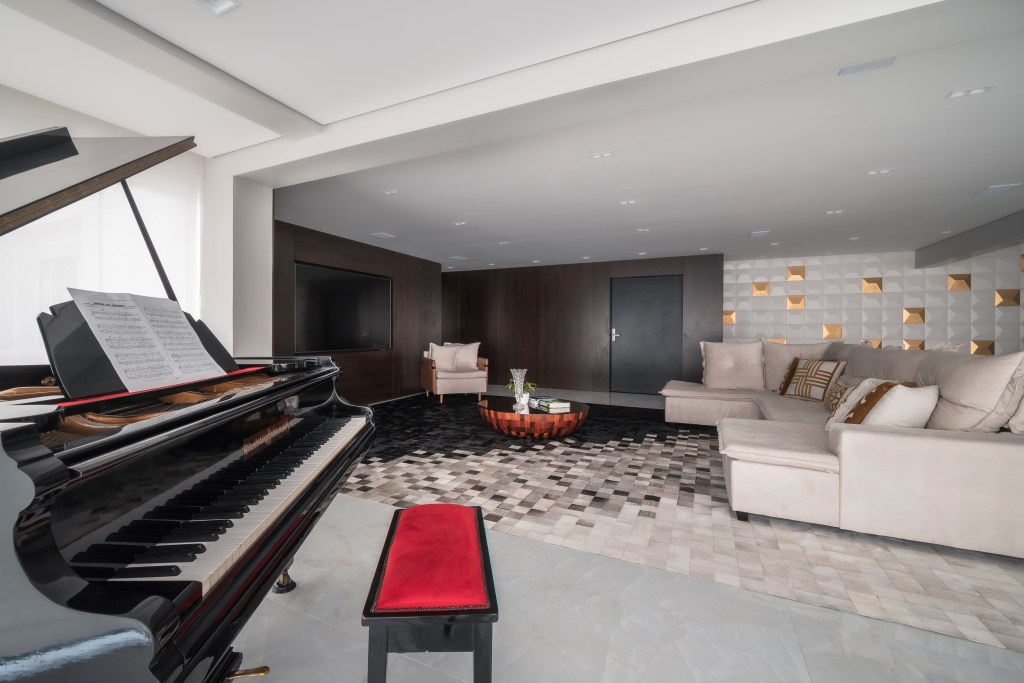 Sala com sofá e tapete quadriculado; piano em primeiro plano