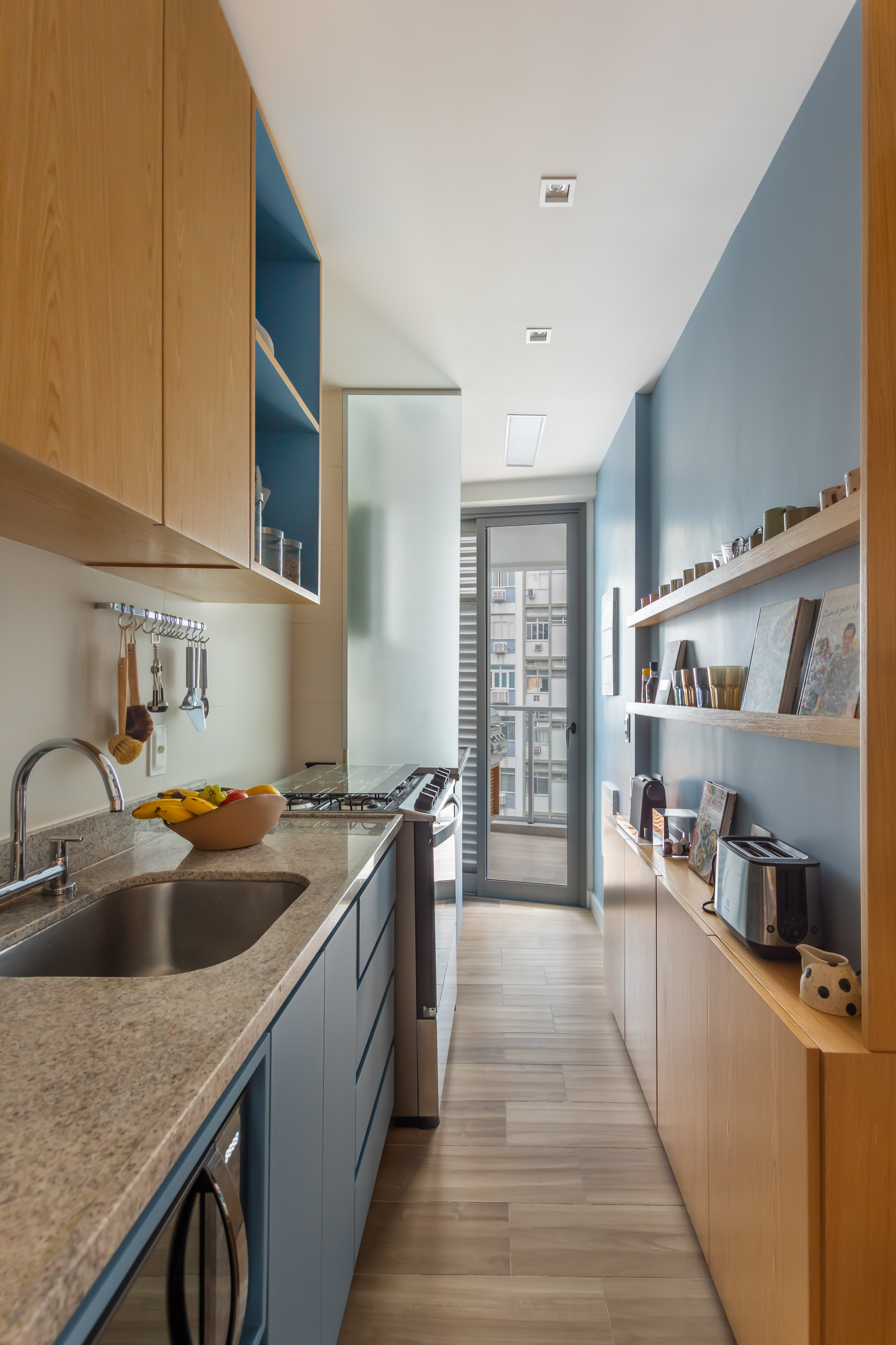 Cozinha estreita com marcenaria azul.