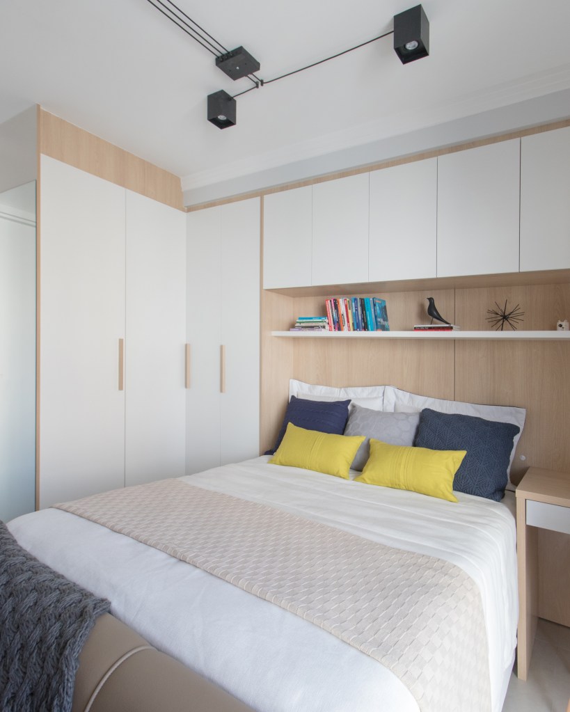 Apartamento pequeno de 29 m² possui lavanderia, home office e cama de casal, Projeto de Letícia de Nóbrega. Na foto, quarto de casal com armários brancos.